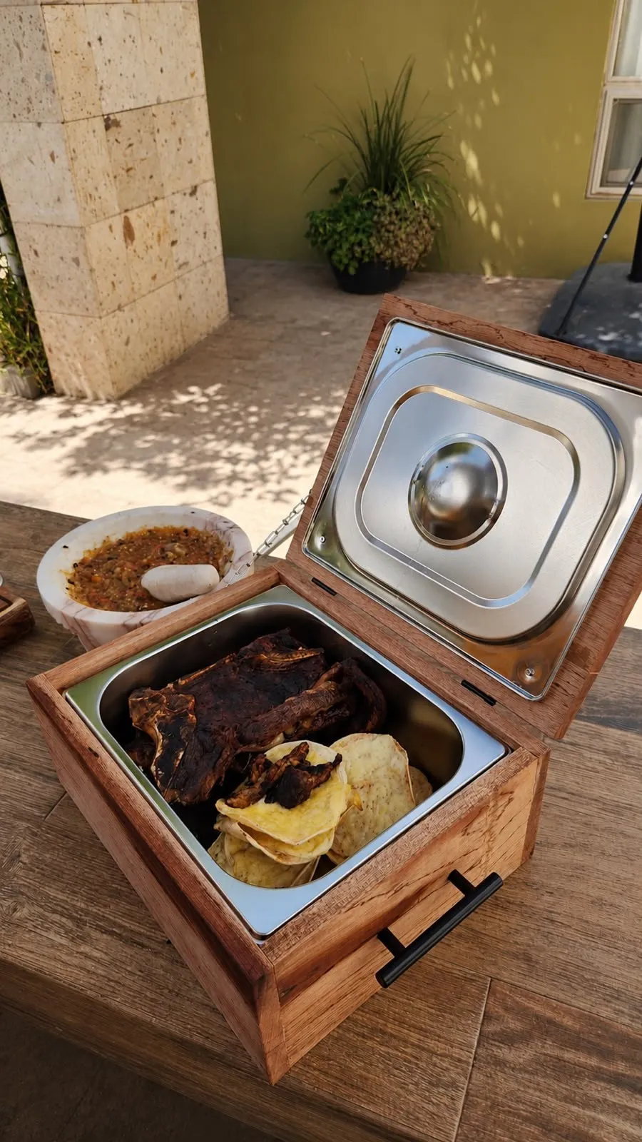 Grill Box abierta con costillas y papas en el patio