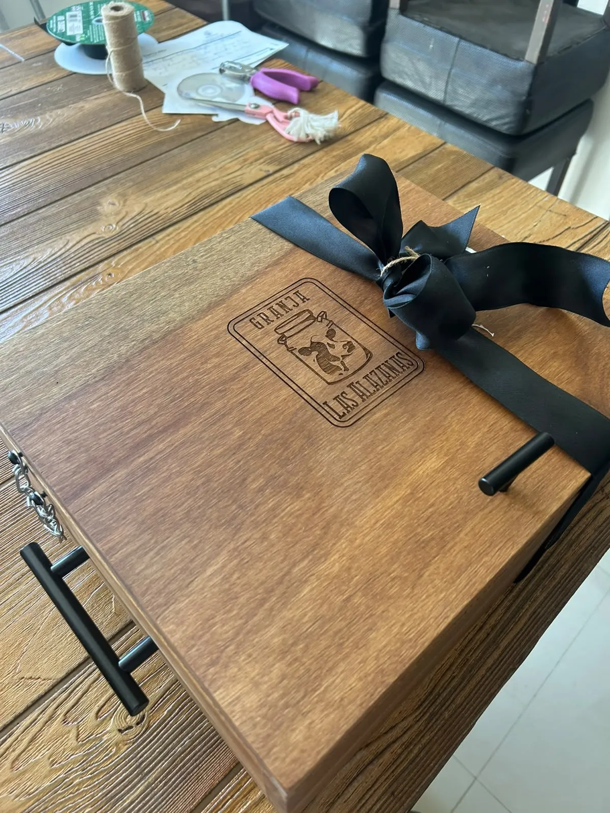 Tapa con el sello de Granja Las Alazanas grabado y moño negro