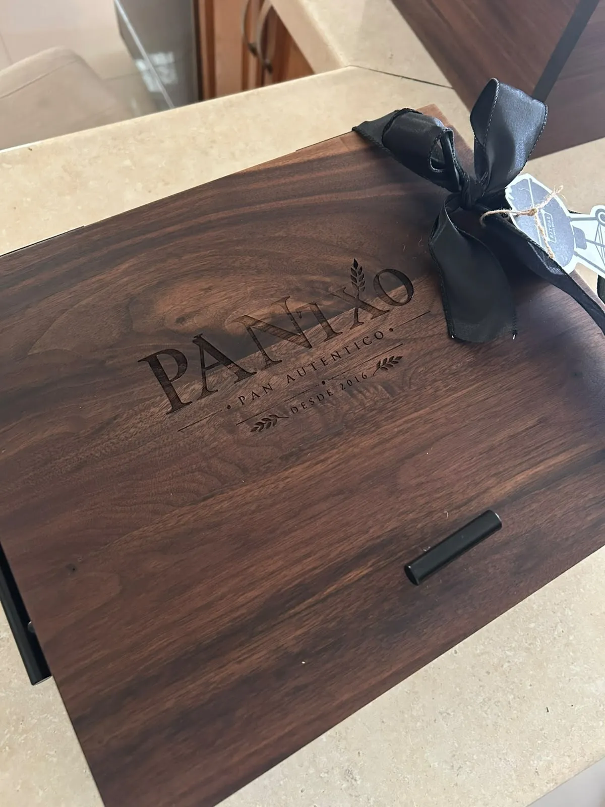 Tapa de nogal con el logo de Panixo grabado